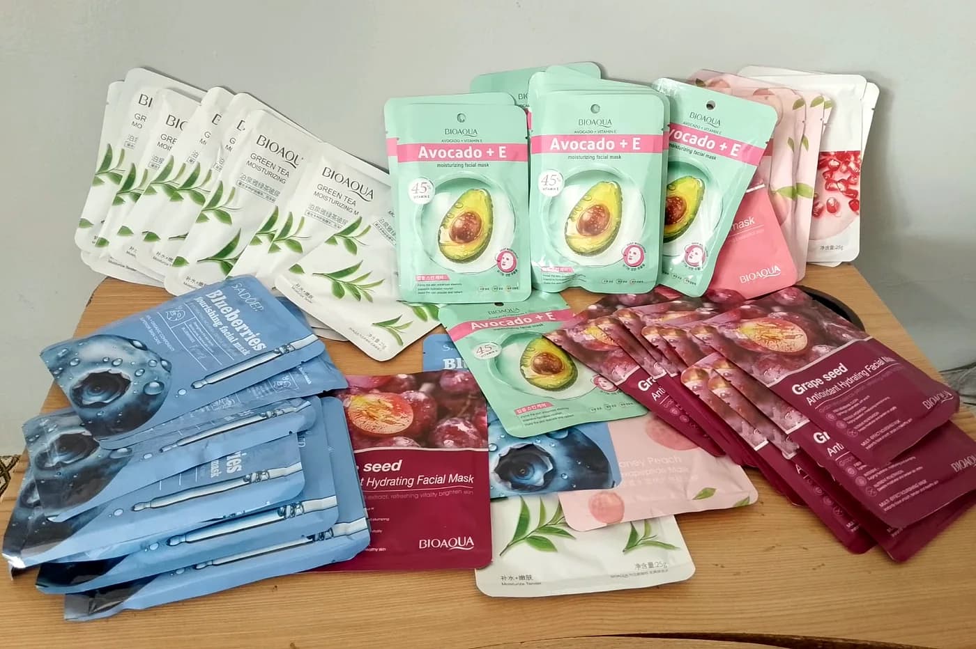 Bioaqua and Sadoer sheet mask sachets spread out on a table